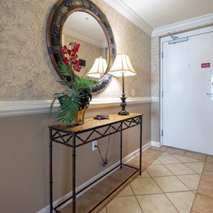 Enter a welcoming hallway featuring a decorative mirror, a stylish table, and soft lighting for a warm first impression