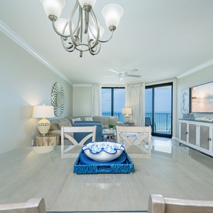 Dine at the glass table with a decorative bowl, while enjoying views of the beach from the inviting living space