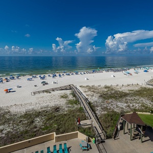 Enjoy breathtaking views of the beach and vibrant umbrellas from this inviting balcony, perfect for relaxation