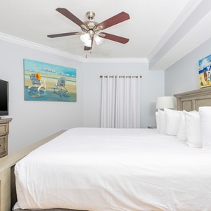 Experience restful nights in this spacious master bedroom, enhanced by soft bedding and vibrant coastal art