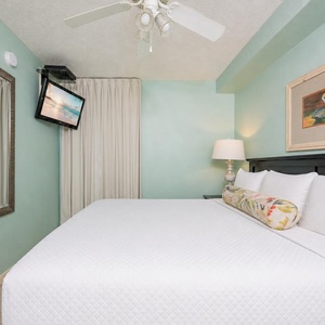 Fluffy pillows invite you to relax in the king suite for a calm movie night after a fun day at the beach