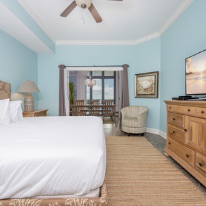 Inviting master bedroom featuring a plush king bed, a cozy chair, and a stunning view through sliding glass doors