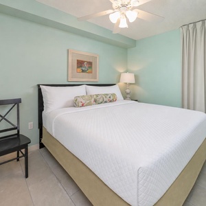 Rest comfortably in the serene bedroom featuring a plush king bed, soft lighting, and calming teal walls