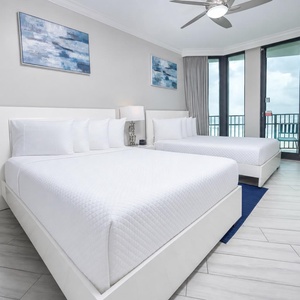 Relax in this inviting guest bedroom featuring two queen beds, stylish decor, and large windows for scenic views