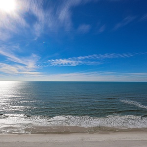 Experience breathtaking views of the shimmering water and soft waves from your beachfront suite