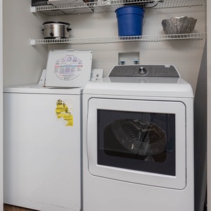 The laundry area features a washer and dryer, with convenient shelving for storage, making chores easy during your stay