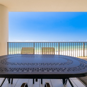 Enjoy spectacular views from the spacious balcony featuring a stylish table and comfortable seating overlooking the beach