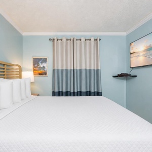Drift into relaxation amidst plush bedding while enjoying your favorite shows on the wall-mounted TV