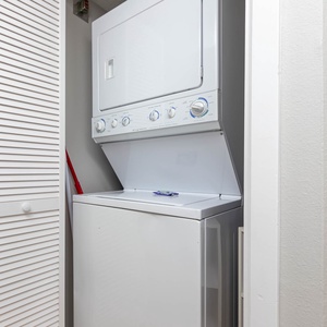 A stacked washer and dryer are neatly tucked away in a closet, providing convenient laundry options during your stay