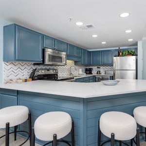 Bright lighting fills the kitchen as you gather around the breakfast bar for casual conversation and coffee