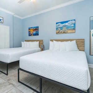 Relax on one of the cozy queen beds in this guest suite with charming coastal decor and enjoy a peaceful slumber