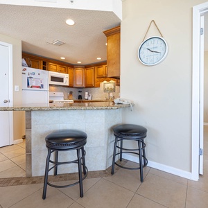 Gather around the bar stools at the kitchen counter, enjoying easy access to the kitchen and inviting decor