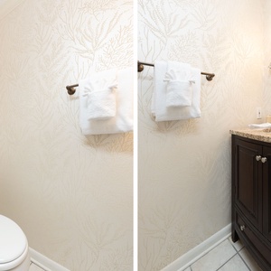 Towels fan out neatly while shell-framed mirror shines gently in the additional half bath