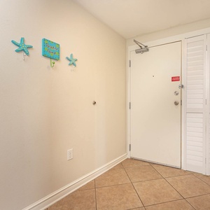 Bright entryway featuring decorative starfish hooks and a welcoming sign, setting a cheerful tone for your beach getaway