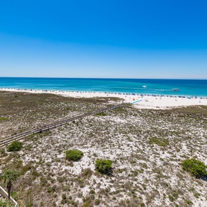 A boardwalk leads you from pools shaded by blue umbrellas to the bright white beach and gentle shore waters