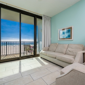 Relax in the inviting living area featuring a comfortable sofa with queen sleeper and beachfront balcony access