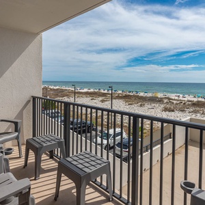 This balcony features gray seating and offers a beautiful beachfront view, perfect for relaxation and enjoying the scenery