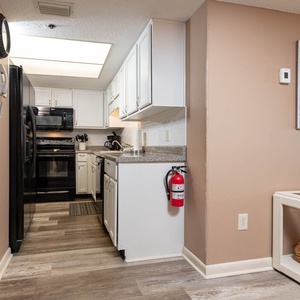 Kitchen featuring sleek black appliances, granite countertops, coffee maker and stylish decor for a welcoming experience