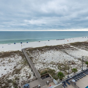 Breathtaking view of the pristine beach and inviting pool area, perfect for a relaxing getaway by the water
