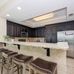 Gather around the sleek bar area with comfortable stools, perfect for casual meals and conversation during your stay