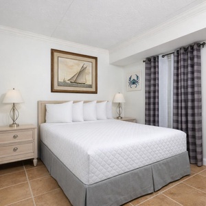 This inviting bedroom features a comfortable bed, nautical decor, and soft lighting for a relaxing retreat
