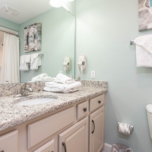 Rejuvenate in this guest bathroom, where soft towels and airy decor create a refreshing space