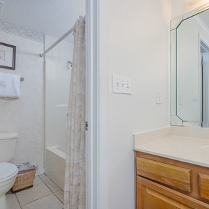 Warmly decorated master bath features a spacious countertop with neatly stacked towels and a shower area