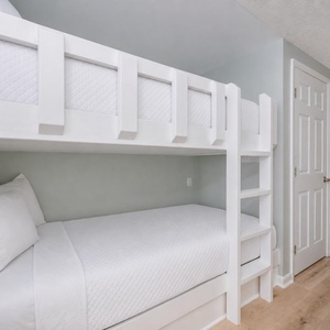 Soft pillows and crisp bedding create a restful sleeping area with twin bunk beds perfect for kids