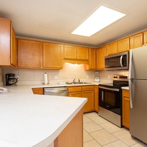 Prepare meals in the spacious kitchen featuring ample cabinetry, stainless appliances, and a convenient breakfast bar