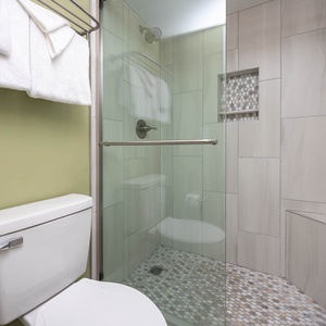 Modern master bathroom featuring a sleek walk-in shower with elegant tile work and plush towels for a refreshing experience