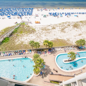 Enjoy a vibrant pool and lazy river area with lush palm trees and easy beach access, perfect for relaxing and fun in the sun