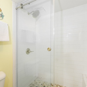 Master bathroom featuring a walk-in shower with a glass door and decorative seashell accents on the wall