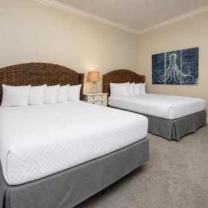 Dream of restful nights in this cozy guest room, featuring plush queen beds and charming coastal decor