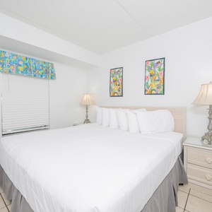 Relaxing bedroom featuring a plush king-size bed and colorful artwork, perfect for a relaxing getaway