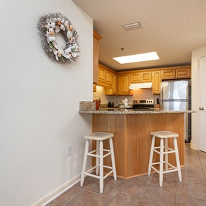 Kitchen area featuring stainless appliances, warm wood cabinetry, and a decorative coastal accents