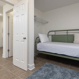 The closet in the master features two green metal twin daybeds, soft pillows, and a plush rug for added comfort