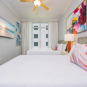 Drift into comfort surrounded by soft queen bedding and vibrant art, perfect for cozy evenings and restful nights
