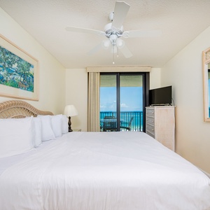 Relax in the master bedroom featuring a king bed, coastal decor, and a lovely beachfront view