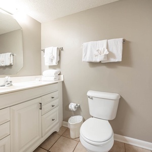 Bright and airy guest bathroom featuring a spacious vanity, neatly arranged towels, and a relaxing ambiance for your getaway