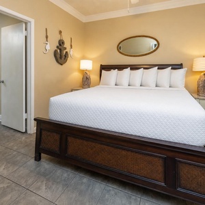 A cozy guest bedroom features a king bed with plush pillows, nautical decor, and soft lighting for a relaxing atmosphere