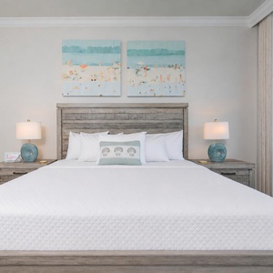 Experience restful nights in the master suite featuring a king bed, soft linens, and beach artwork