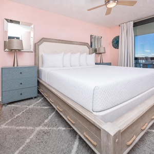 Spacious master bedroom featuring a large king bed, modern furnishings, and access to the gulf front balcony