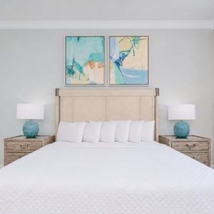 Experience restful nights in this master bedroom with a king bed, stylish decor, and soothing artwork above