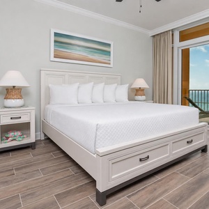 Retreat to the king master suite with cozy bedding and drift off to the sound of the waves from the balcony