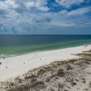 Enjoy the scenic view of the beach with colorful umbrellas and gentle waves, perfect for relaxation and fun