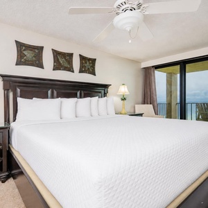 The master bedroom features a plush king bed, elegant decor, and a breathtaking view from the balcony