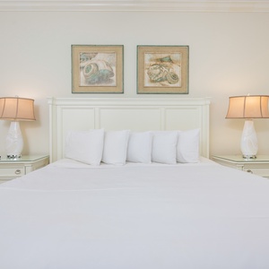 Relaxing guest bedroom featuring a white king bed with decorative pillows and stylish bedside lamps