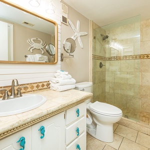 Indulge in relaxation in the master bath, where the walk-in shower and coastal decor elevate your self-care routine