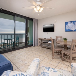 Relax in the inviting living area with comfortable seating and a mounted TV and enjoy views of the beach from the balcony