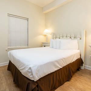 Relax in this comfortable guest bedroom featuring a queen bed, soft lighting, and a charming decor that invites rest